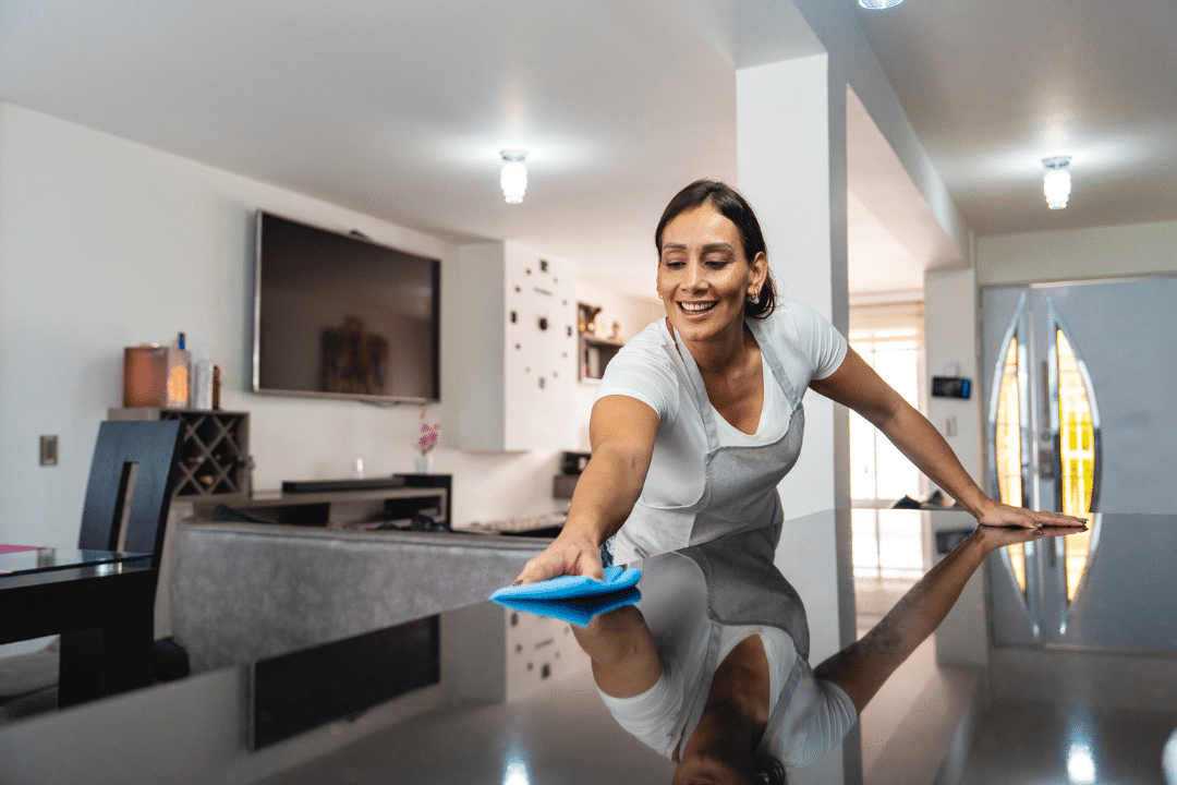 Professional cleaner wiping and polishing a kitchen island during a detailed residential deep cleaning service.
