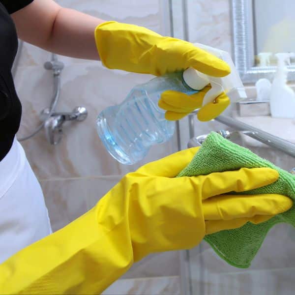 A professional house cleaners scrubbing a shower in a Chatham, NJ home.