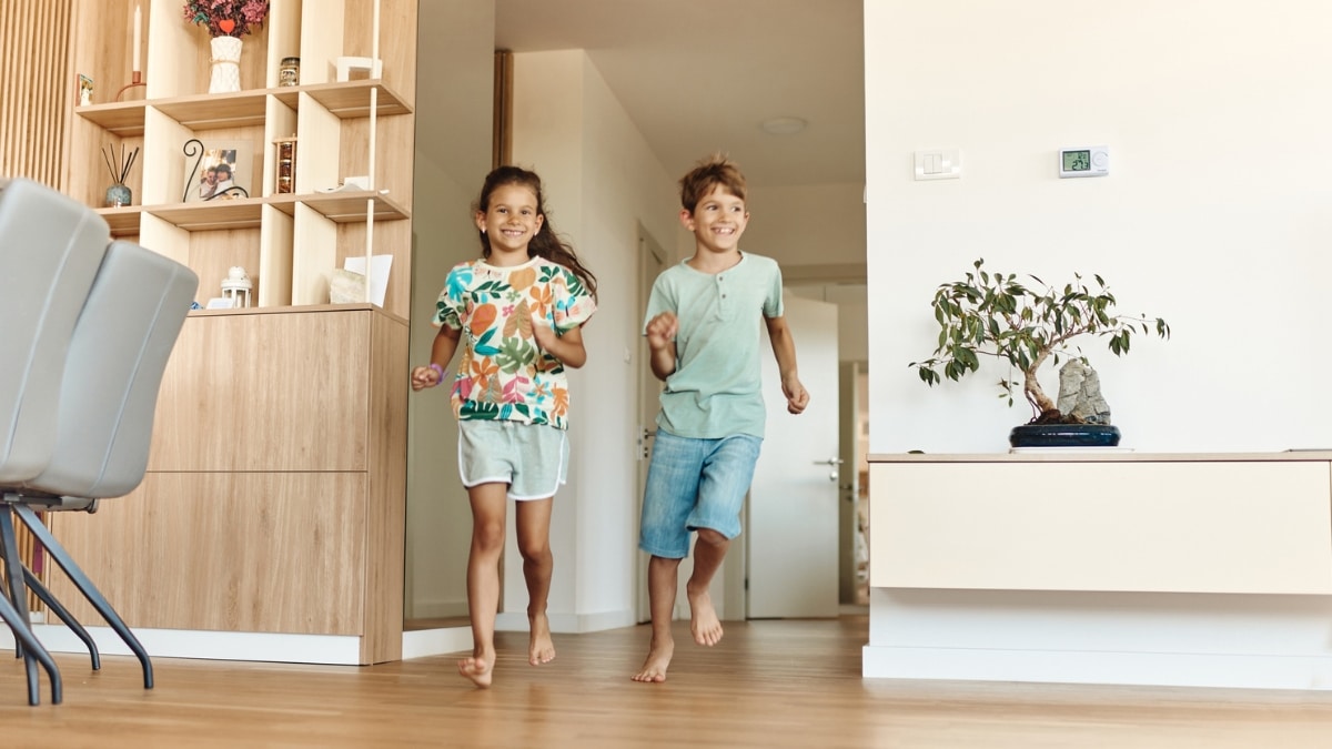 Children smiling and playing in a clean, well-maintained home after maid service.